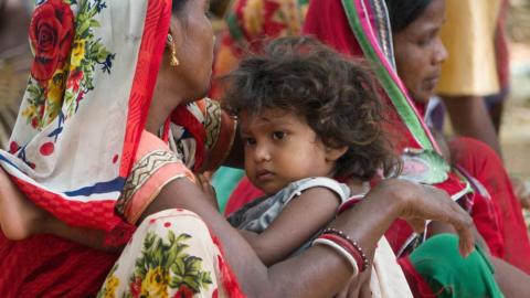 A child sleeping on her mother's lap